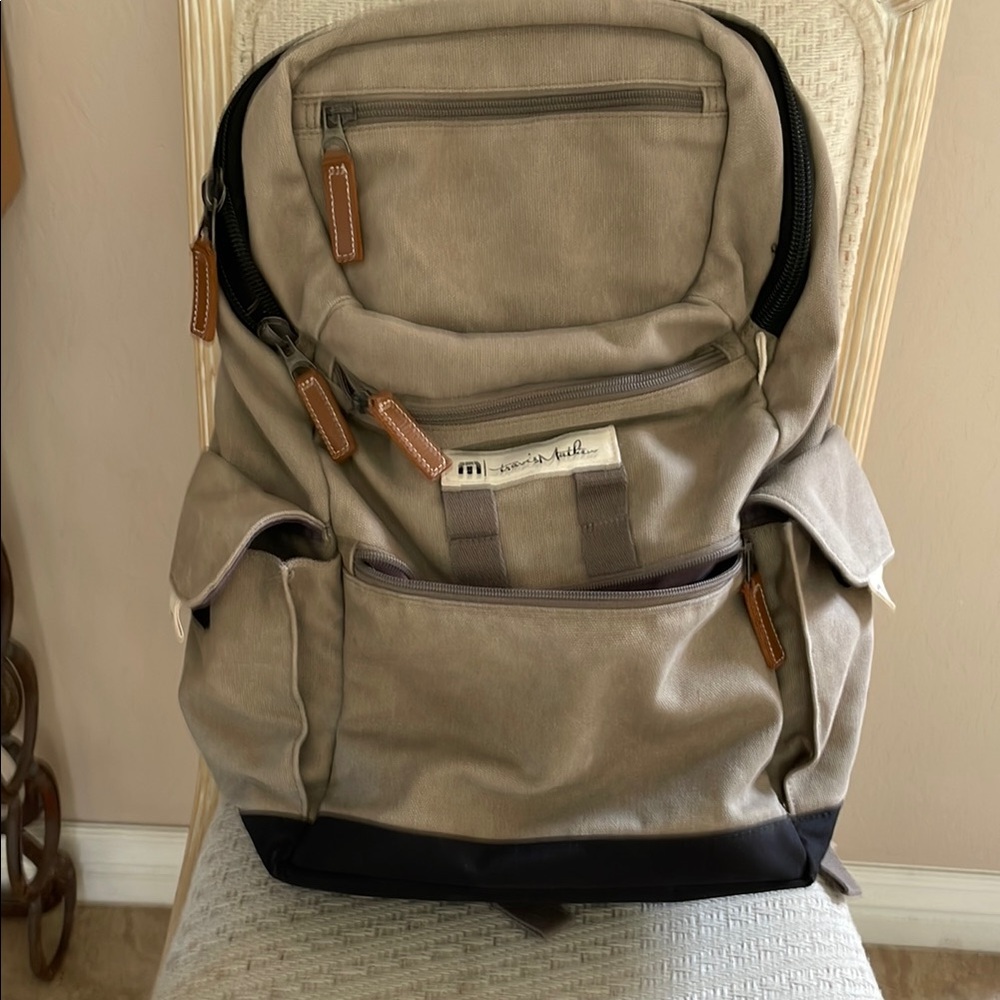 Travis Mathew Tan Backpack with 
4 zippered pockets,2 Velcro side pockets